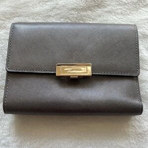 Tumi Tri-fold Women’s Wallet. Silvery Gray with gold accents. New without Tags